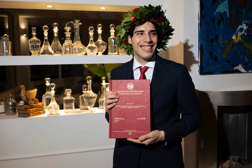 Laureato mostra il diploma durante i festeggiamenti
